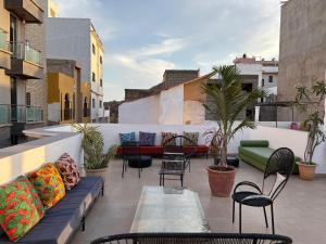a patio with a couch and chairs on a balcony at La Maison des Couleurs in Dakar