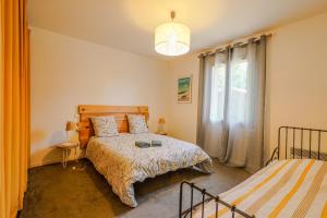 a bedroom with two beds and a window at L'Eyre de vacances -Proche Lac Arjuzanx - jeux - terrasse - plancha - in Luglon