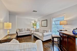 a living room with two couches and a table at Charming West Palm Beach Home in West Palm Beach +13 photos