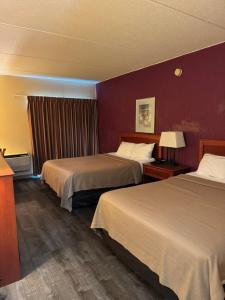 a hotel room with two beds and a red wall at Motel Sun Inn in Winthrop Harbor