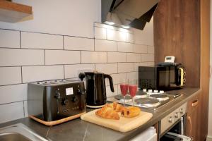 a kitchen with a toaster and croissants on a counter at Wood & Teal Nest in Bradford +39 photos