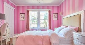 een roze slaapkamer met een bed en een raam bij Hollywood Deluxe Homestay in Los Angeles