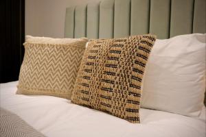 a pillow sitting on top of a bed with white pillows at Wood & Teal Nest in Bradford