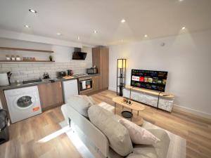 a living room with a couch and a kitchen at Wood & Teal Nest in Bradford