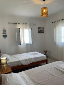 a bedroom with two beds and a chandelier at A Casa da Cilarca in Portel