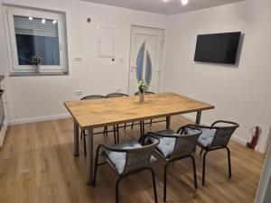 a dining room with a wooden table and chairs at Hygge-Kuca in Neum