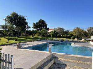 una piscina in un parco con sedie e alberi di MONTE DO CHAPARRO by Stay in Alentejo a Vila Nova de Milfontes