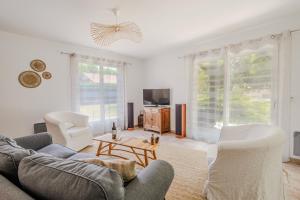 a living room with a couch and chairs and a tv at L'Eyre de vacances -Proche Lac Arjuzanx - jeux - terrasse - plancha - in Luglon
