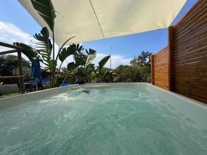 - un bain à remous avec un parasol dans l'arrière-cour dans l'établissement Blue Velvet Rooms, à Tortolì