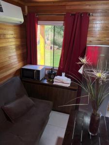 a living room with a couch and a window at Sítio Recanto Nativo in Palmitos