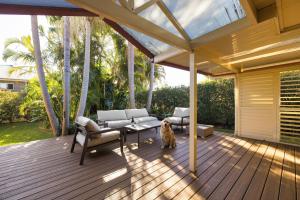 a dog is sitting on a wooden deck at Pawprints in Corlette