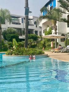 two children swimming in a swimming pool at a resort at Ocean Symphony in Îlot de Skhirat