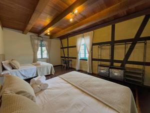 a room with two beds and two windows at Casa Enxaimel Aurora in Pomerode