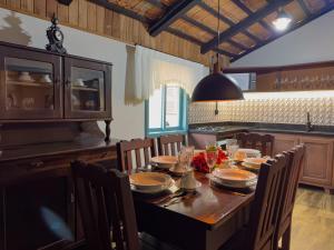 a dining room with a table with chairs and a kitchen at Casa Enxaimel Aurora in Pomerode