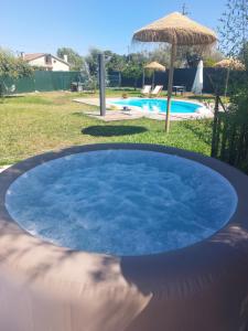 a large pool of blue water with an umbrella at Casas Zé Pinto in Hospital
