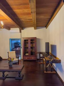 a living room with a wooden ceiling and a table at Casa Enxaimel Aurora in Pomerode