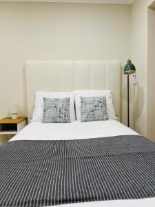 a bed with a black and white striped sheets and pillows at Apartamento Central - Lisbon in Lisbon