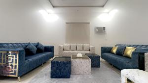 a living room with blue couches and a table at فيلا المروج الفندقية in Yanbu