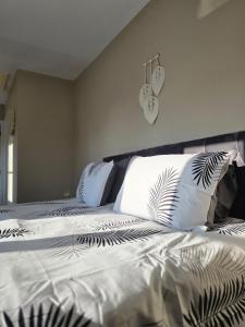 a bed with white pillows and a clock on the wall at Spacious & Homely Colchester Stay-Great Location in Hythe