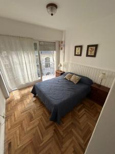 Schlafzimmer mit blauem Bett und Holzboden in der Unterkunft Depto 2 ambientes Zona Aldrey in Mar del Plata + 11 Fotos