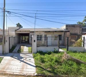 a house with a fence in front of it at Alojamiento Lindo Amanecer in Mercedes