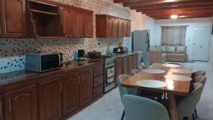 a kitchen with wooden cabinets and a table with chairs at Alojamiento Lindo Amanecer in Mercedes