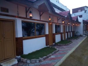 AnaimalaiRoyal Cottage & Party Hall的侧面有灯的建筑物