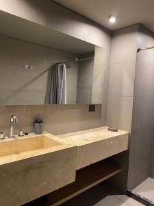 a bathroom with a sink and a large mirror at Edificio Pantera - monoambiente 18 in San Martín de los Andes +17 photos
