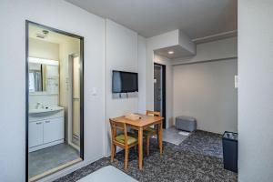 una camera d'albergo con tavolo e bagno di LABEL 01 Dotonbori Aparthotel ad Osaka