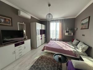 a bedroom with a bed and a flat screen tv at Golden Sun in Pomorie