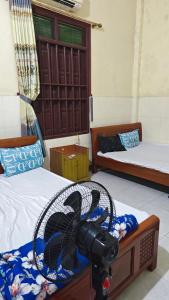 a room with two beds with a fan on them at Hotel KIỀU GIANG in Nga Sơn