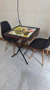 a table with two chairs and a painting on it at Hotel KIỀU GIANG in Nga Sơn