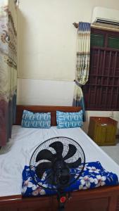 a bedroom with a bed with a fan on it at Hotel KIỀU GIANG in Nga Sơn