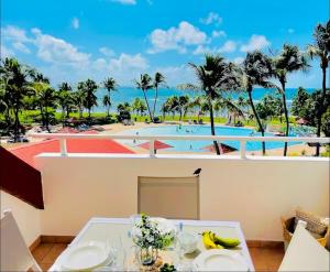 un resort con vista sulla piscina e sulle palme di Appartement vue panoramique mer et piscine a Sainte-Anne
