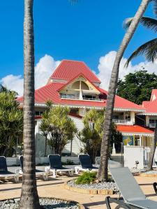 un resort con sedie e palme di fronte ad esso di Appartement vue panoramique mer et piscine a Sainte-Anne