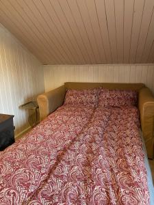 a bed in a room with a red blanket on it at Drangedal Cabin House in Drangedal