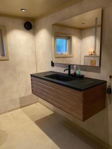 a bathroom with a black sink and a mirror at Drangedal Cabin House in Drangedal +26 photos
