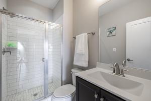 a white bathroom with a sink and a shower at Spacious 4BR House with Private Garage in Washington +25 photos
