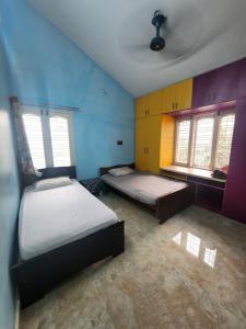 a room with two beds and two windows at Bangalore Chalet in Bengaluru +13 photos