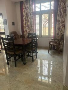 a dining room with a wooden table and chairs at Bangalore Chalet in Bengaluru