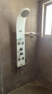 a shower in a bathroom with a shower head at Bangalore Chalet in Bangalore +13 photos