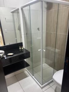 a glass shower in a bathroom with a toilet at Flat Xareuzinho - Praia Antunes in Barra Grande