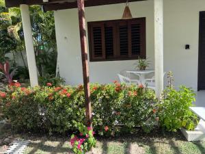 a house with a bunch of flowers in front of it at Flat Xareuzinho - Praia Antunes in Barra Grande +3 photos