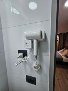 a hair dryer and a phone on a wall at Alojamiento a pasos de Movistar Arenas, Parque O Higgins, Universidad de Chile y Ministerio de Justicia in Santiago +5 photos