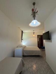 a bedroom with two beds and a chandelier at La Marinella in Lamezia Terme