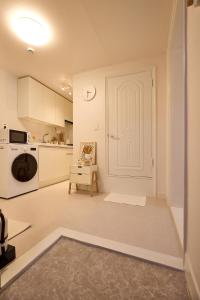 cocina blanca con puerta blanca y silla en Stay Luna, en Seúl 77 fotos más