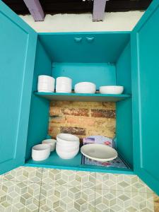 a blue cabinet with white bowls and plates in it at AQUI ME QUEDO here I Stay in Bogotá