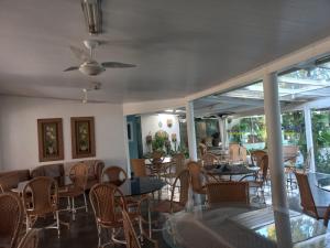 a restaurant with tables and chairs and a ceiling fan at Pousada Irmão Sol Irmã Lua in Abadiânia