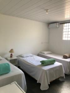 a room with two beds and a window at Pousada Irmão Sol Irmã Lua in Abadiânia