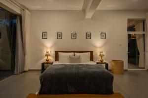 ein Schlafzimmer mit einem großen Bett und zwei Lampen in der Unterkunft Tea Heritage in Urulewatta